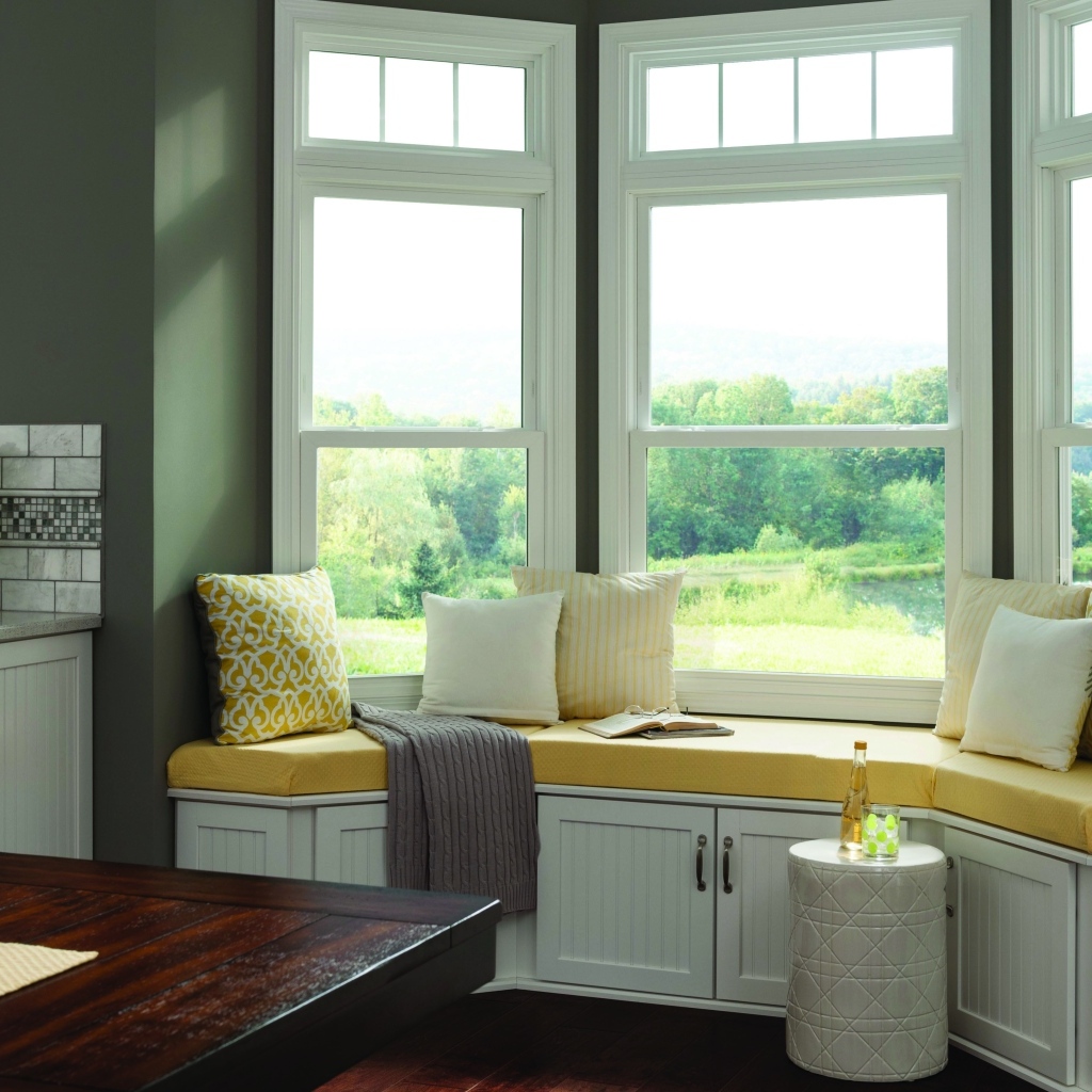 Уютная светлая кухня с эркером в загородном доме в зеленых тонах