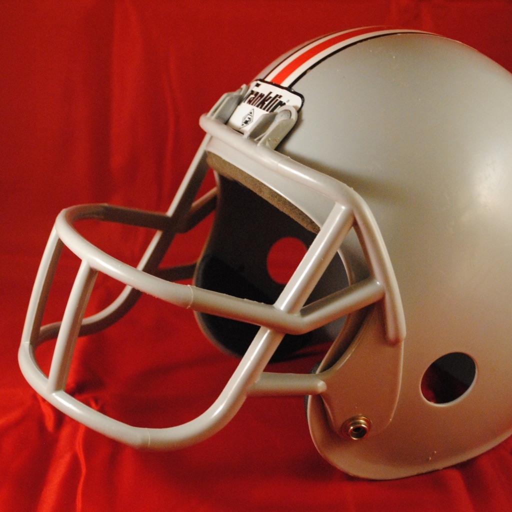 Шлем для игры в американский футбол на красном фоне