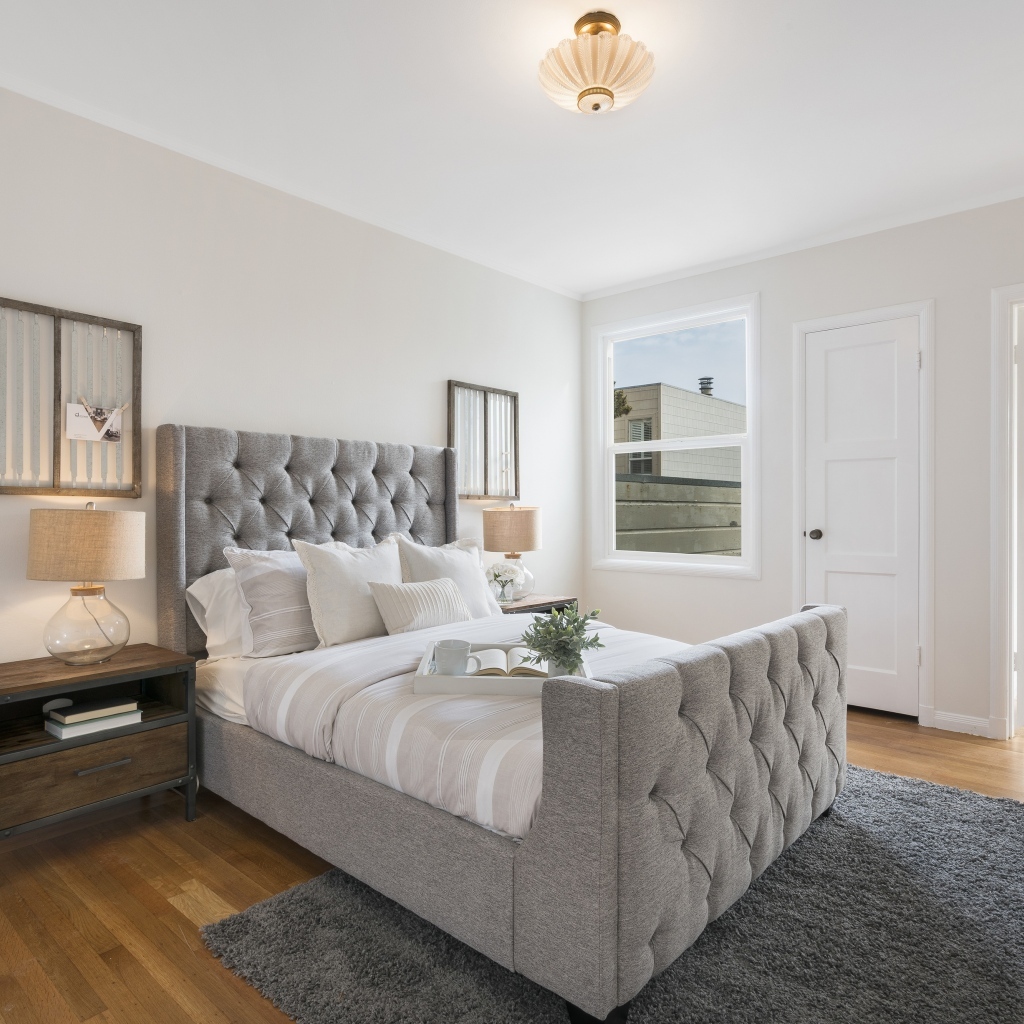 Высокая серая кровать в спальной комнате