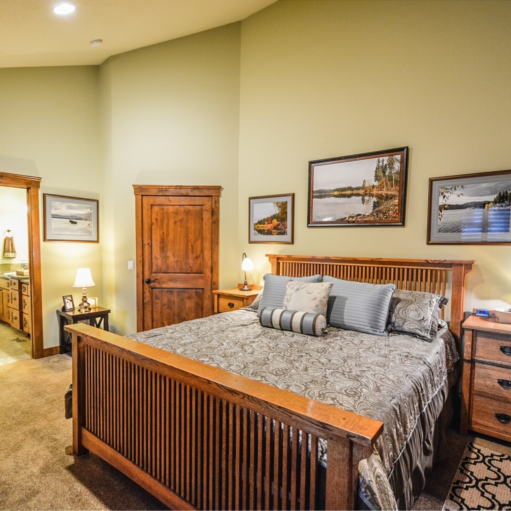 Большая деревянная двуспальная кровать в комнате