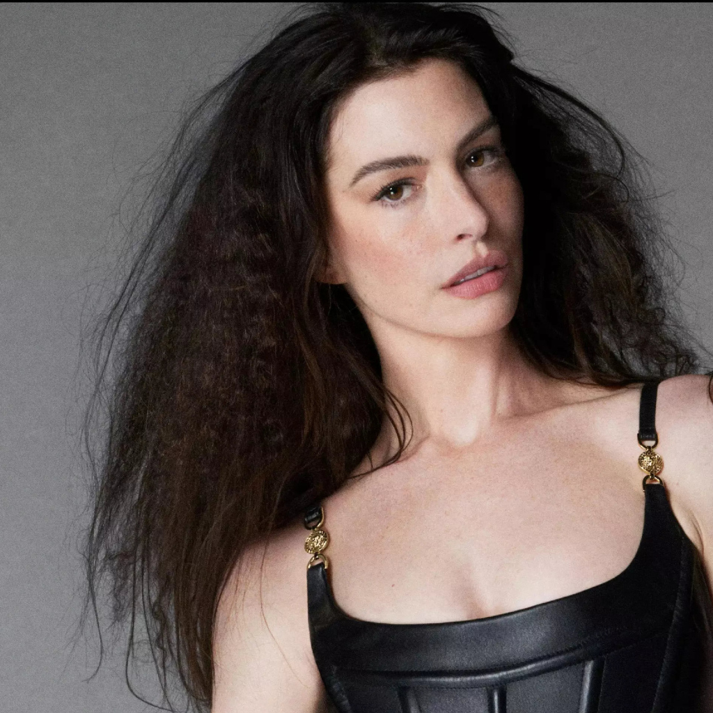 Длинноволосая актриса Энн Хэтэуэй на сером фоне