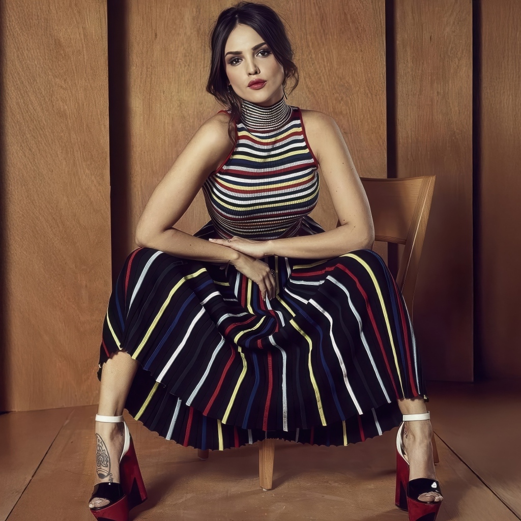 Мексиканская актриса Эйса Гонсалес в юбке сидит на стуле