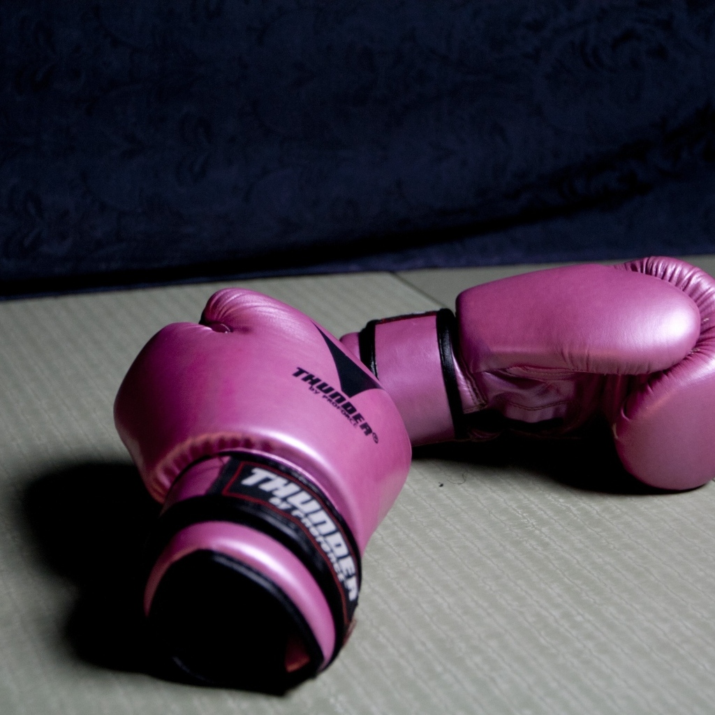 Розовые боксерские перчатки на столе 