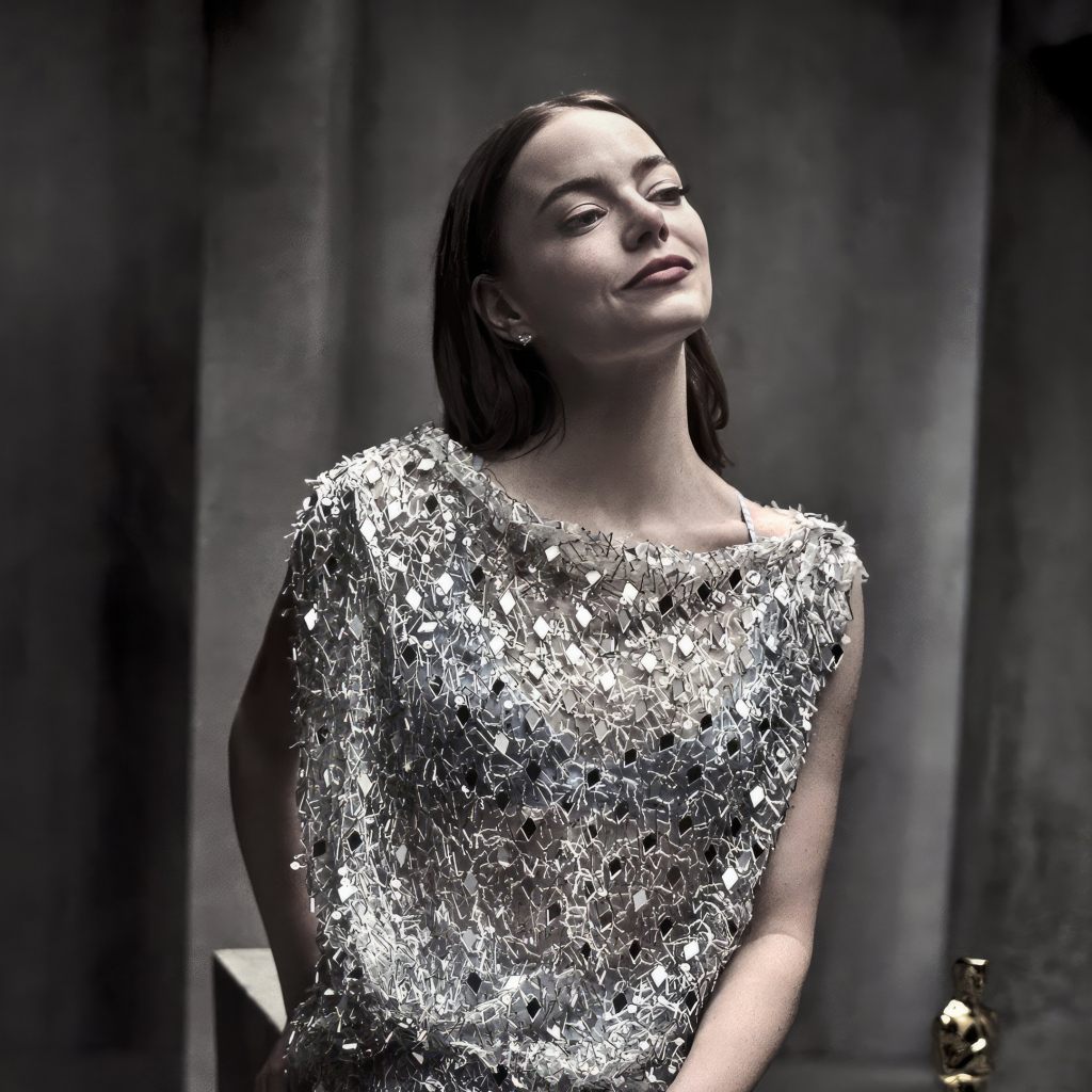 Рыжеволосая актриса Эмма Стоун в блестящем платье в серой комнате
