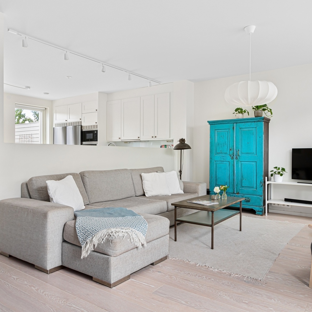 Просторная гостиная комната  с серым диваном