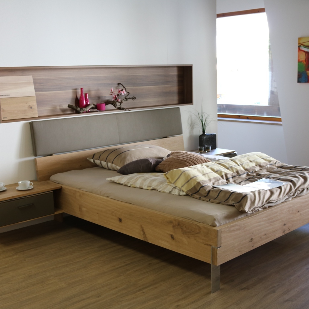 Деревянная кровать на ножках в спальне