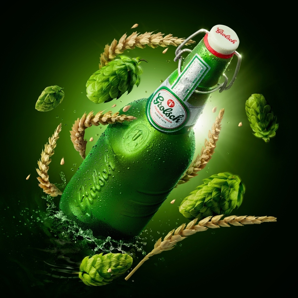 Зеленая бутылка с хмелем и пшеницей на черном фоне