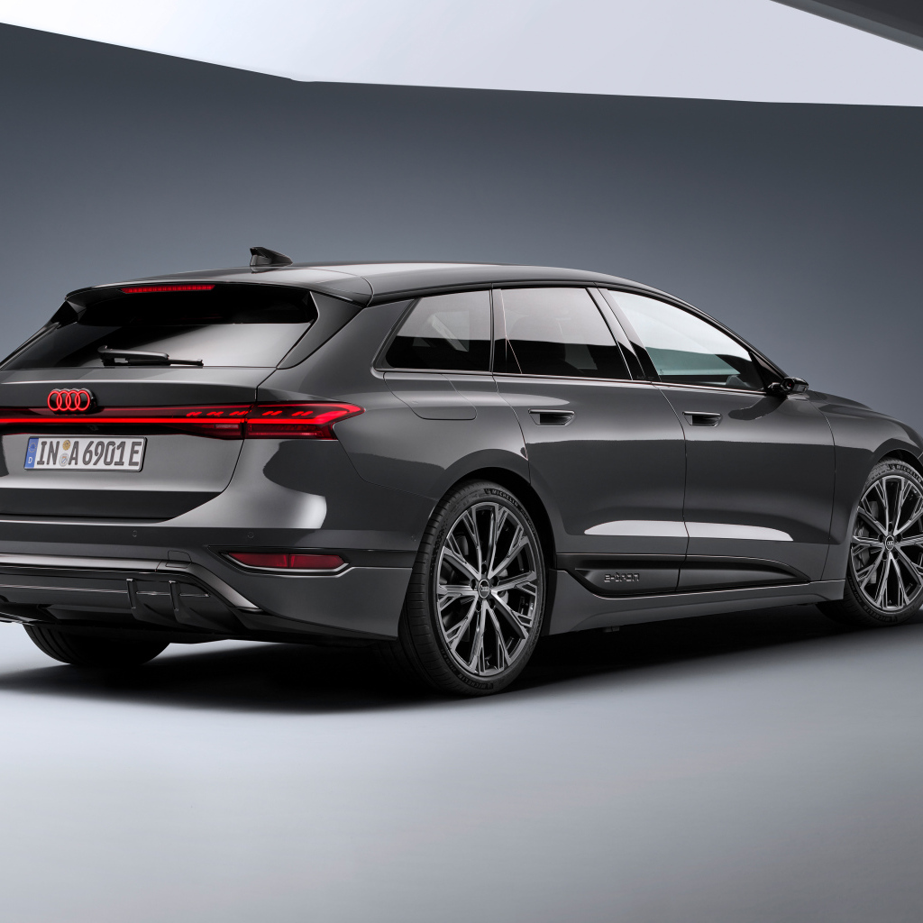 Автомобиль Audi A6 Avant e-tron S line 2024 года на сером фоне вид сзади