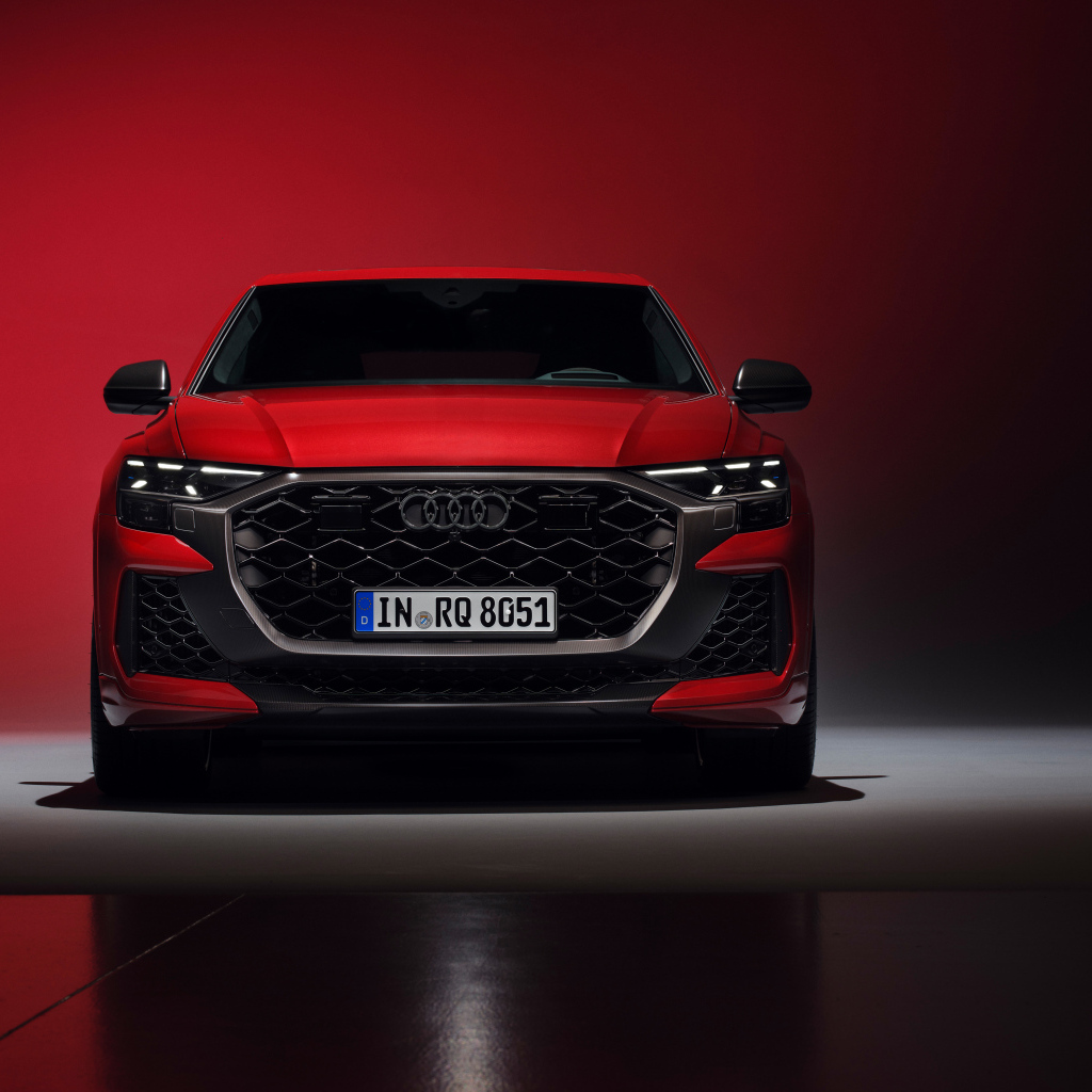 Вид спереди на автомобиль Audi RS Q8 performance 2024 года на красном фоне