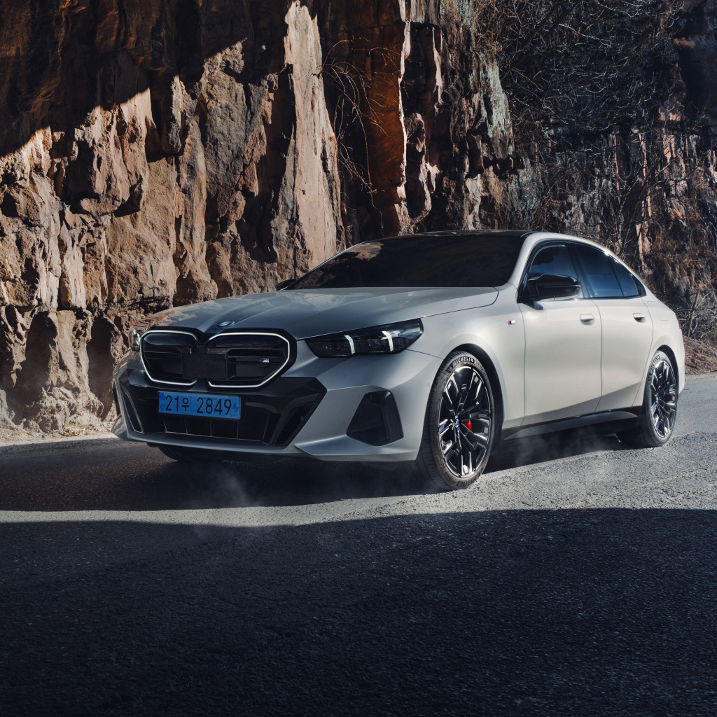 Серебристый автомобиль BMW i5 M60 у горы