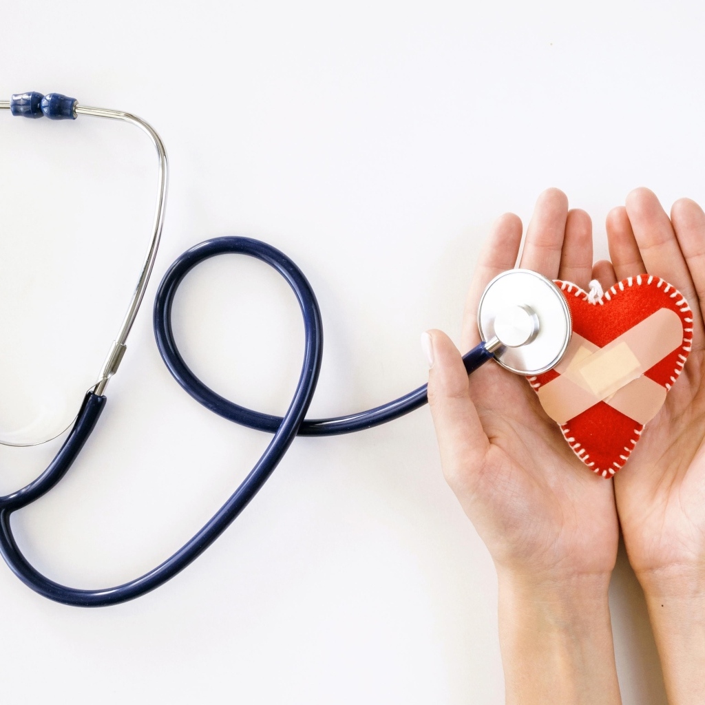 Стетоскоп слушает раненое сердце в ладонях