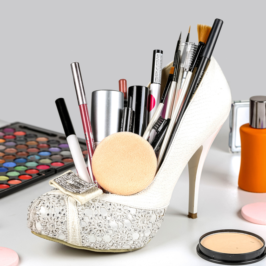 Женские белые туфли наполнены косметикой