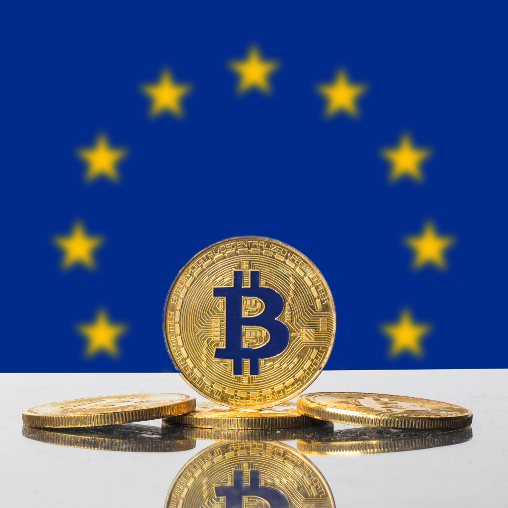 Монеты биткоин на фоне флага Евросоюза