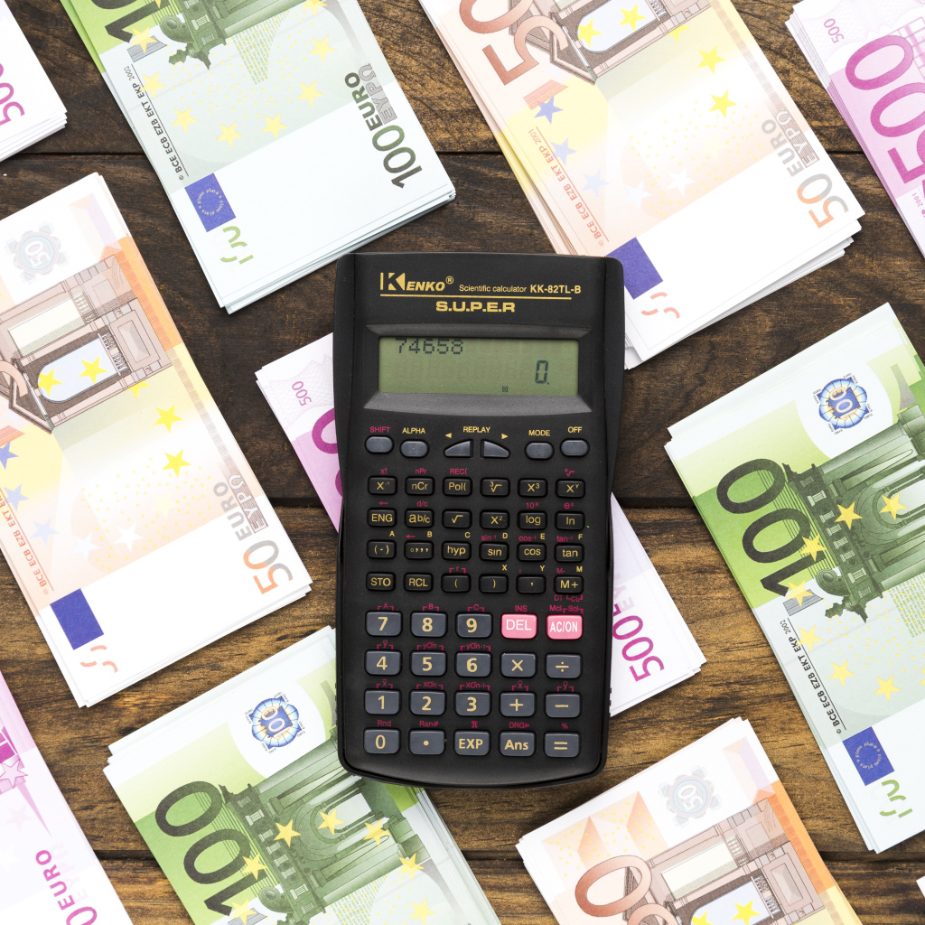 Калькулятор и купюры евро на деревянном столе