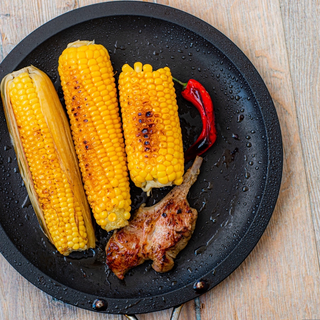 Запеченная кукуруза с ребрышками на тарелке