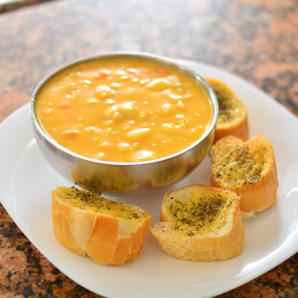 Суп с фасолью на тарелке с гренками