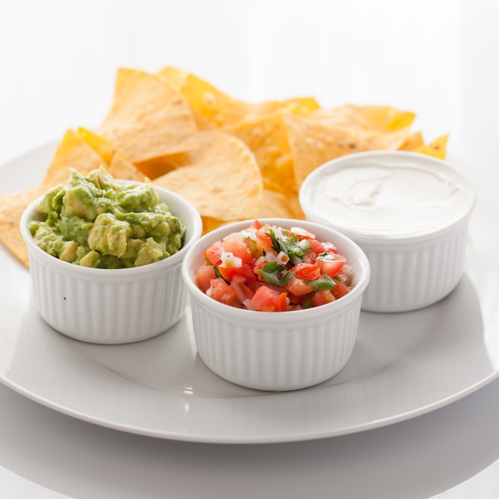 Чипсы с соусом на большой белой тарелке