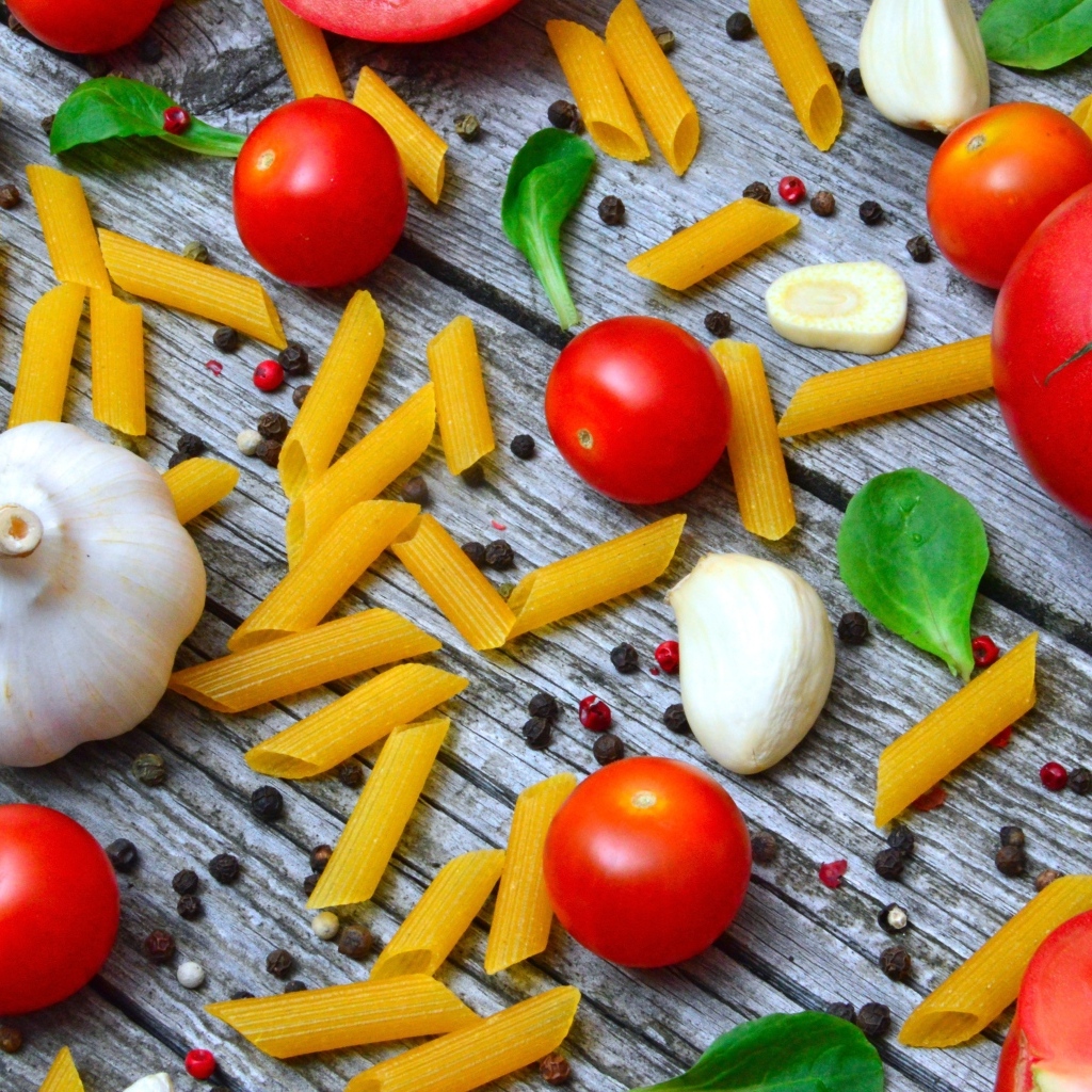 Макароны на столе с помидорами и чесноком