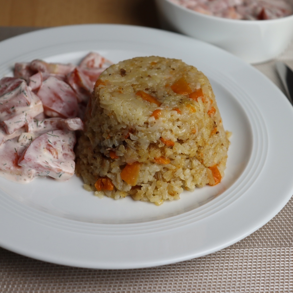 Рис с салатом на большой белой тарелке