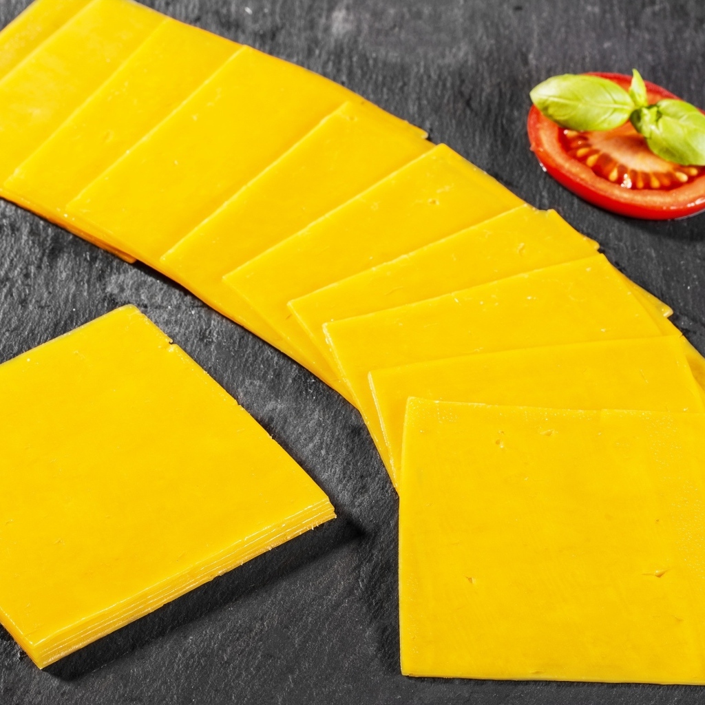 Ломтики сыра с помидором на столе