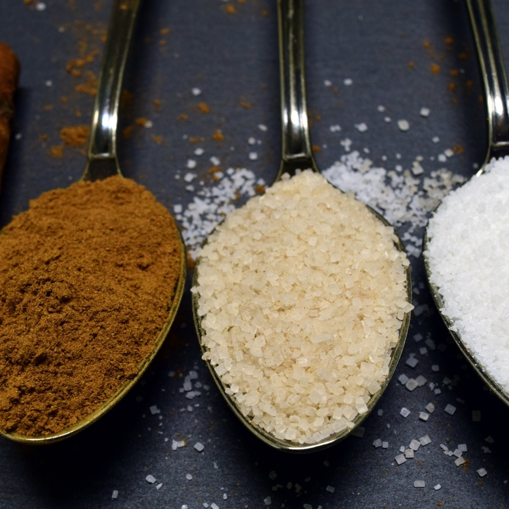 Три ложки со специями на сером столе