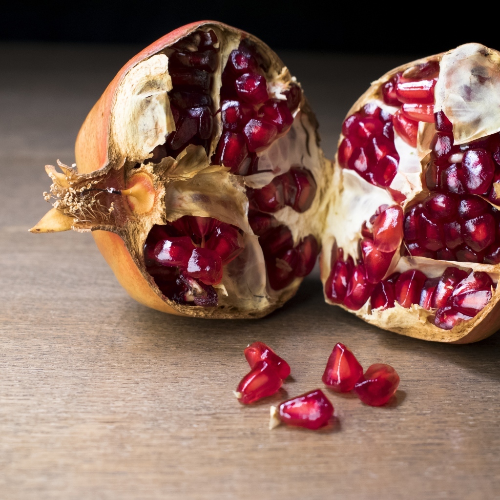 Половины плода граната на столе