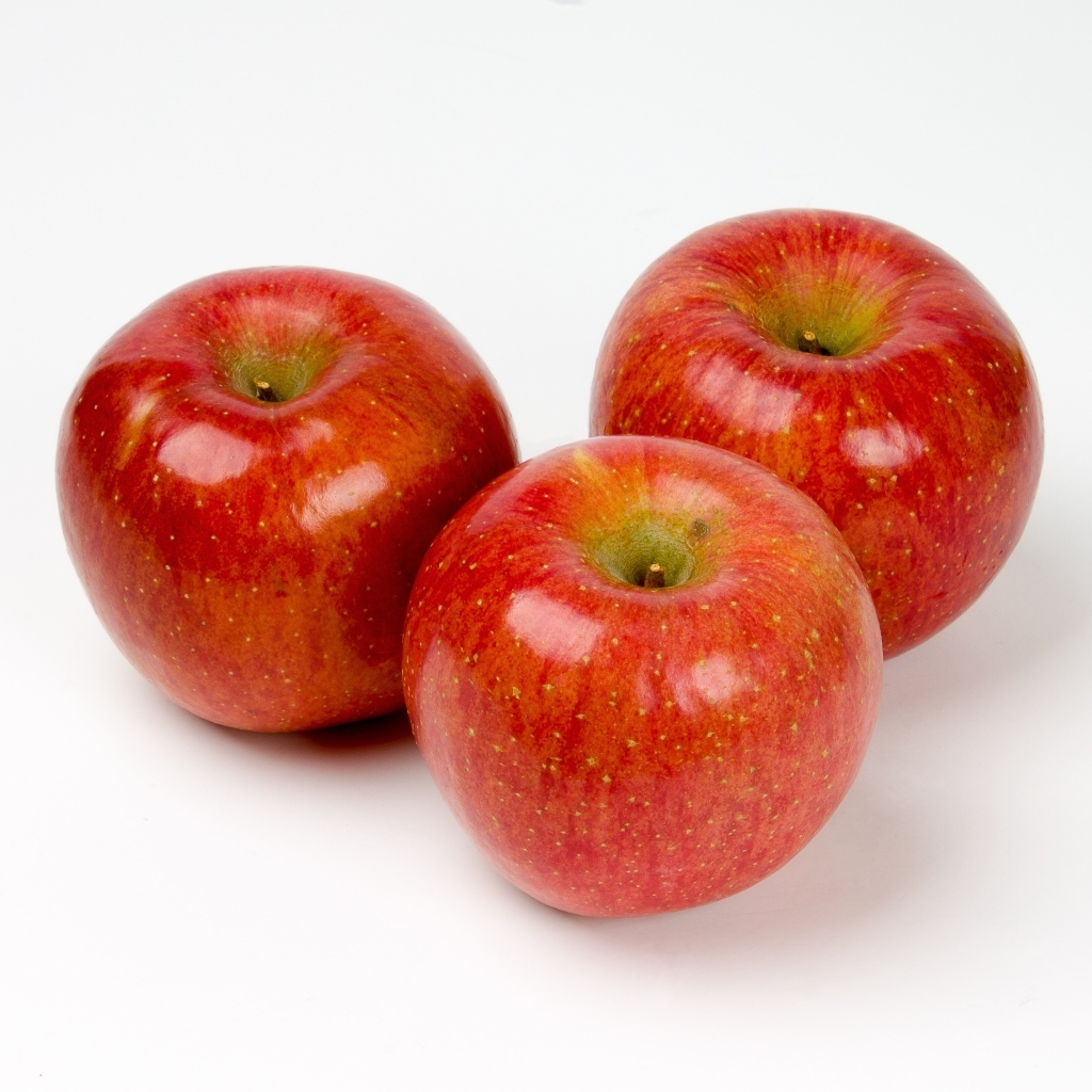 Три красных яблока на белом фоне