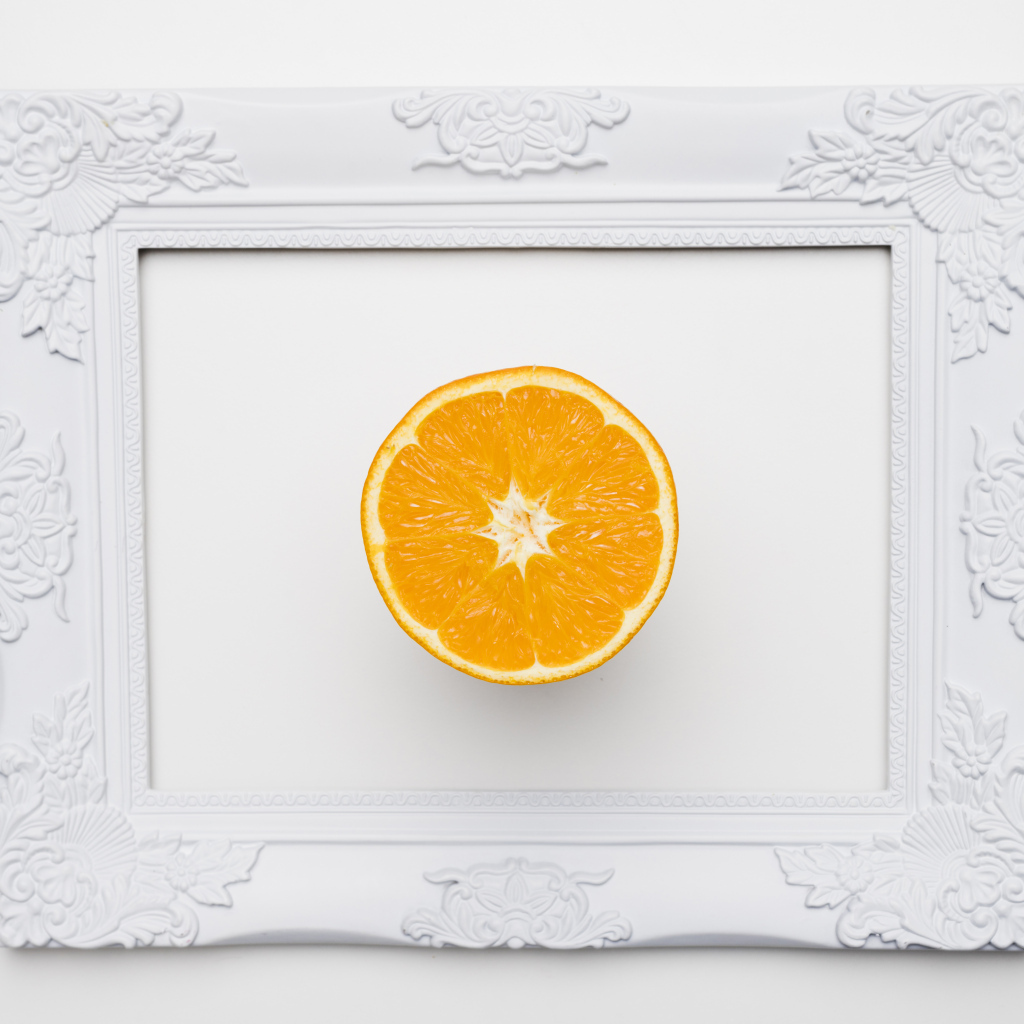Белая рамка для фото с половиной апельсина