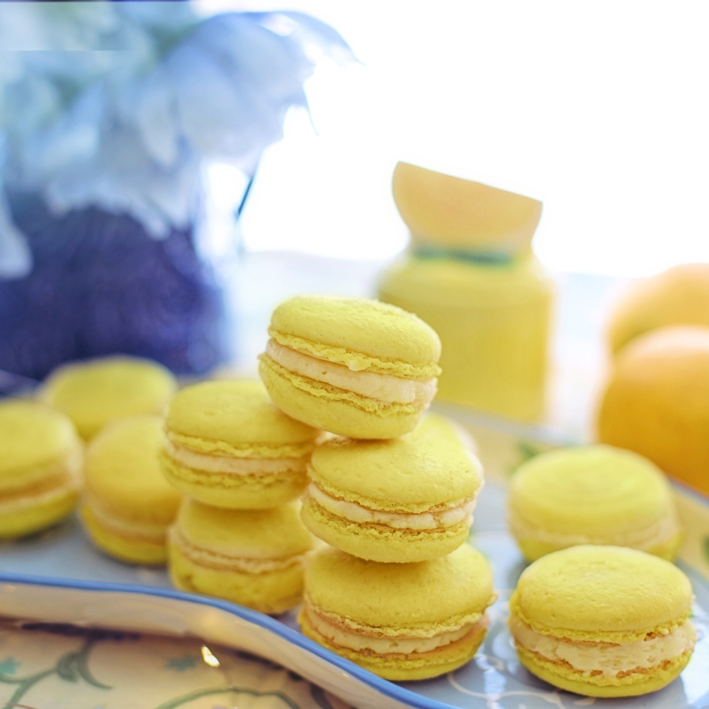 Десерт макарунс желтого цвета на тарелке на столе
