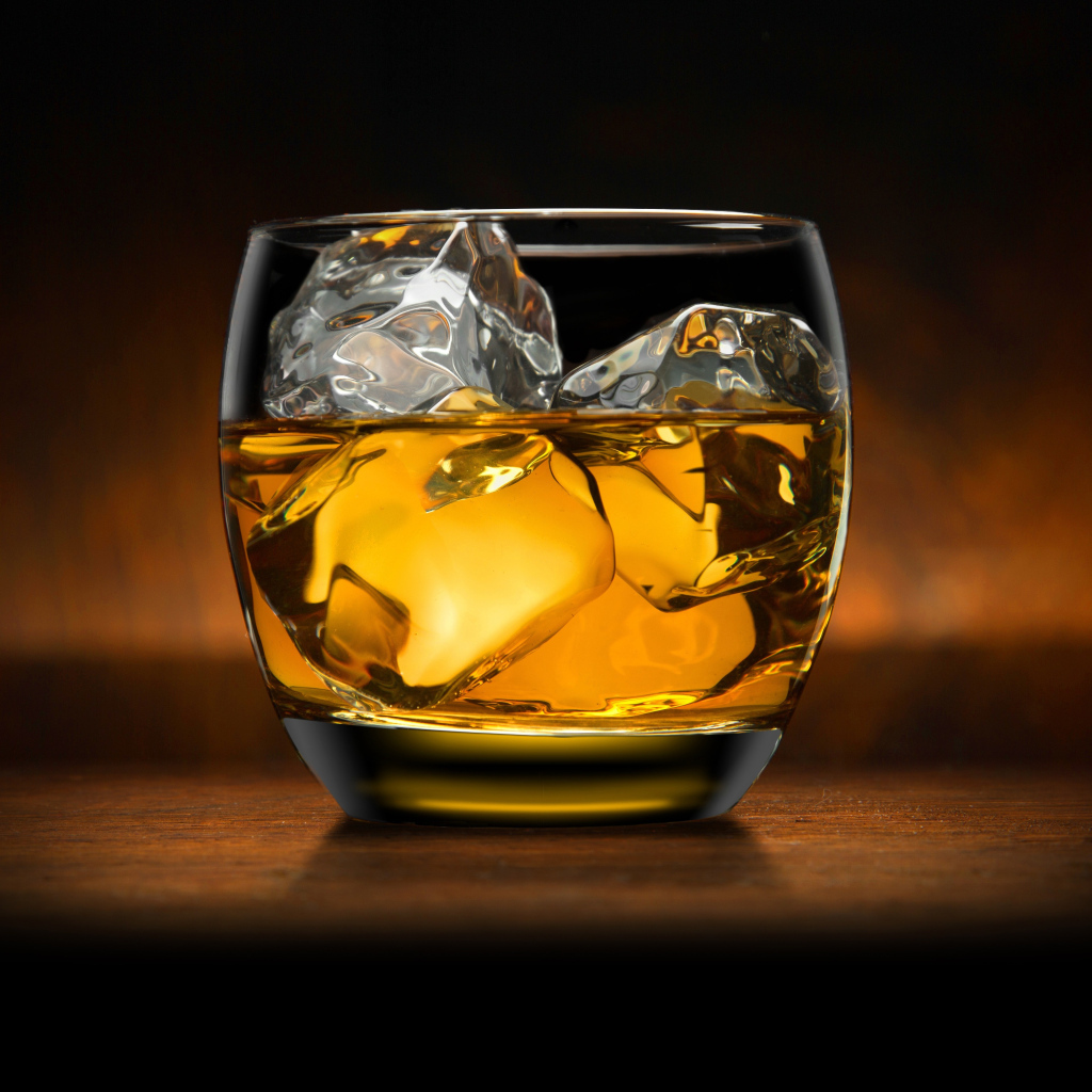 Стакан виски со льдом на столе