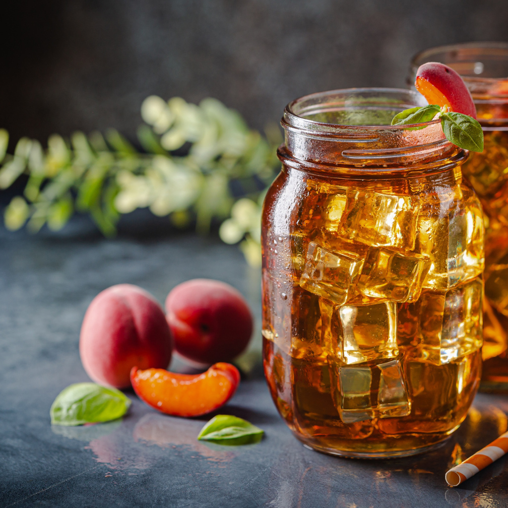 Холодный чай со льдом на столе с абрикосами