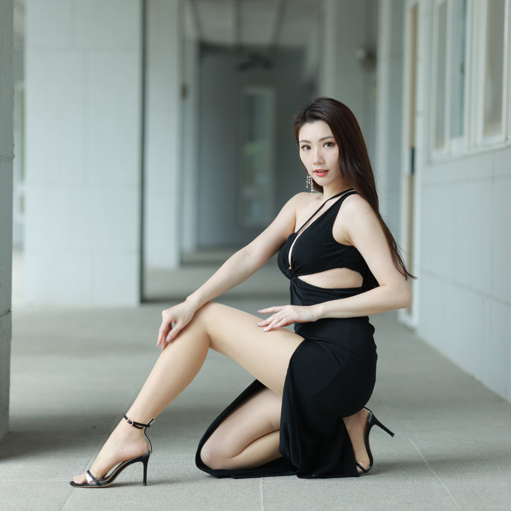 Девушка азиатка в черном наряде позирует для фото