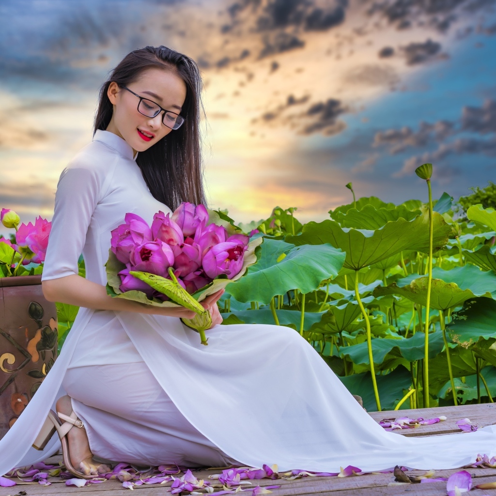 Девушка азиатка в белом платье с цветами лотоса