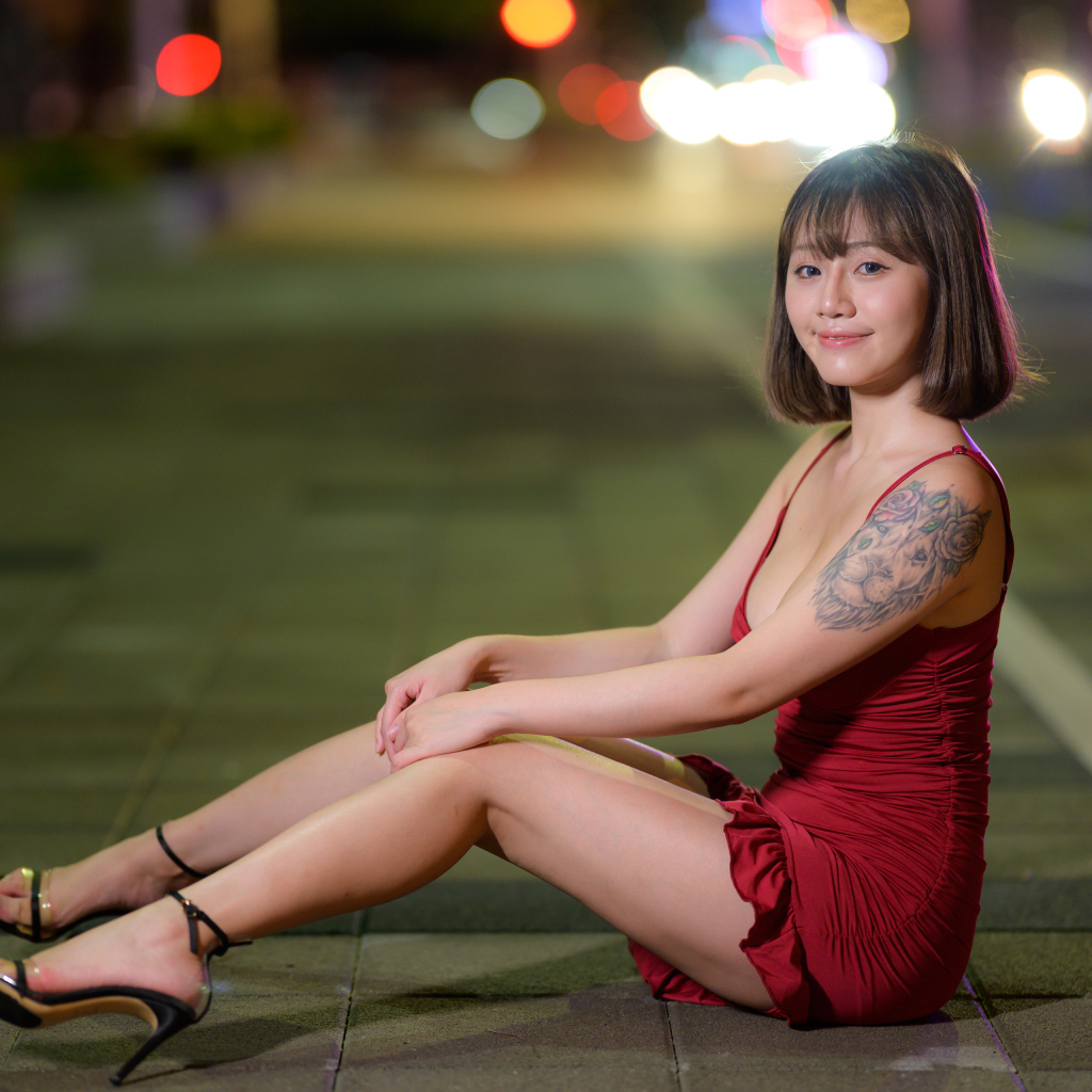 Азиатка с татуировкой на руке в красном платье