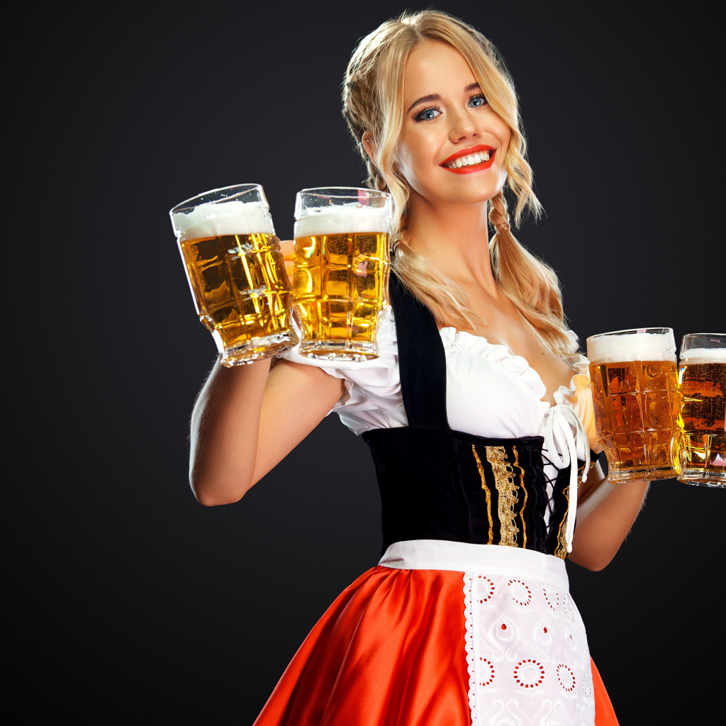 Красивая блондинка немка с бокалами пива на фестивале