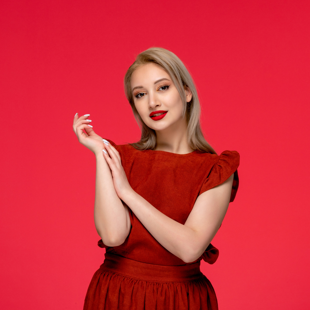 Красивая девушка в красном платье на красном фоне