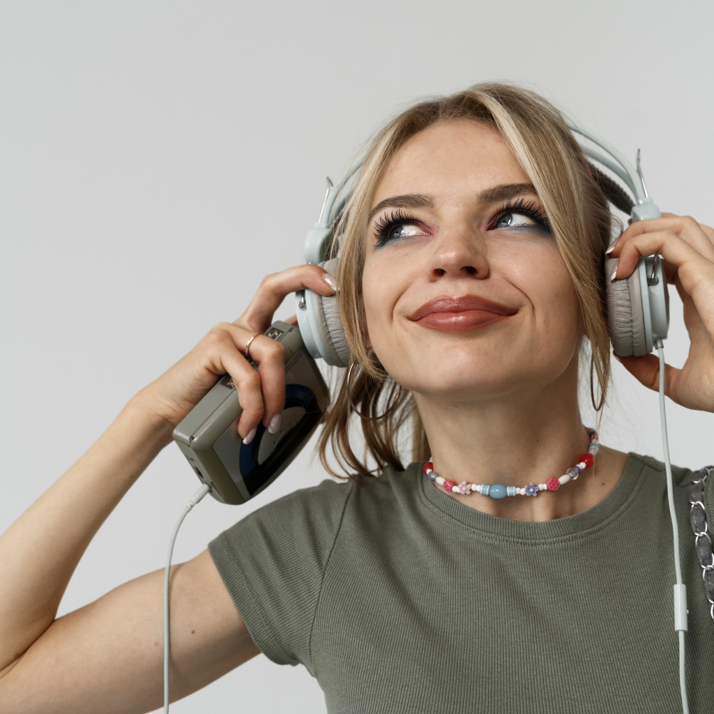 Красивая девушка в наушниках с плеером