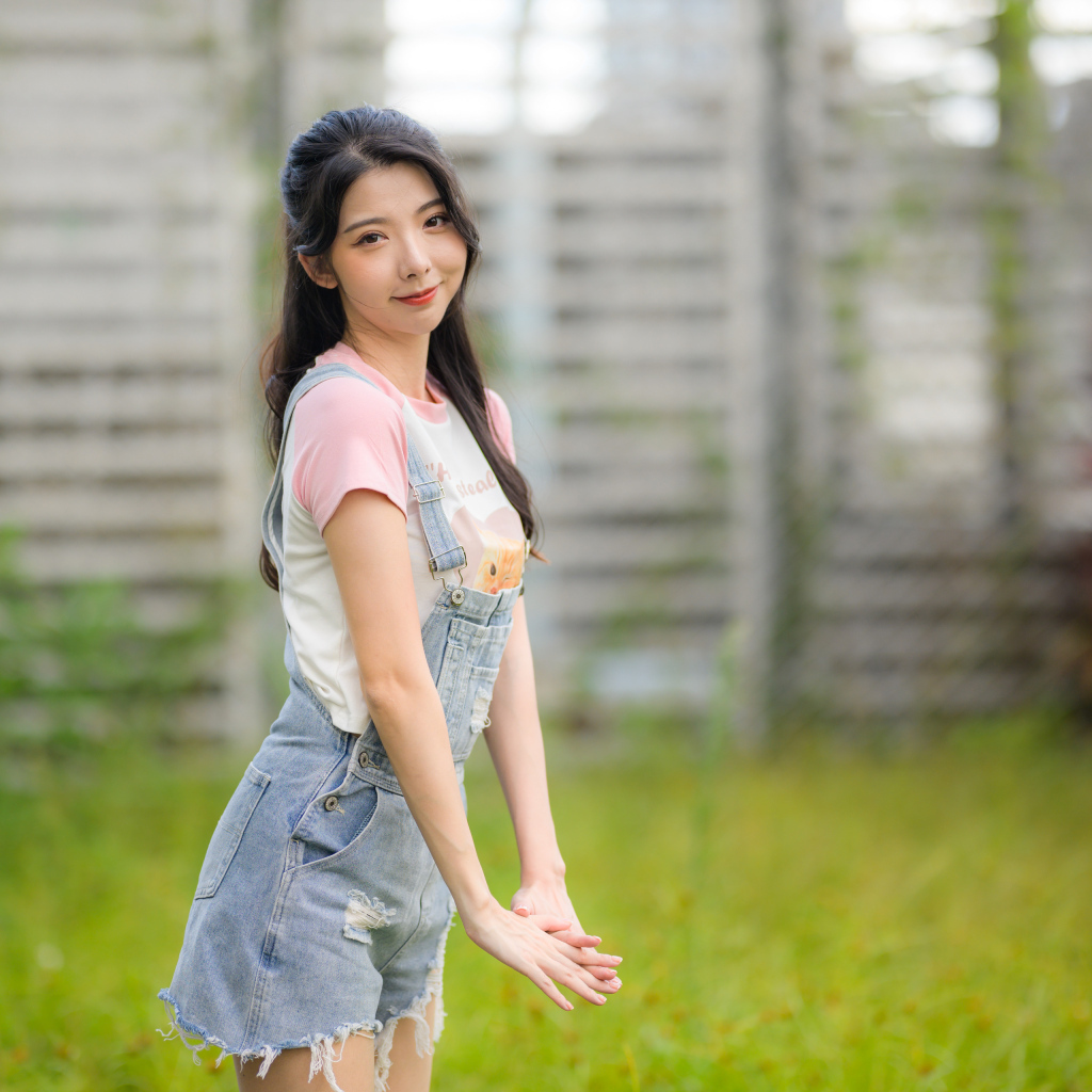 Милая девушка азиатка в джинсовом комбинезоне