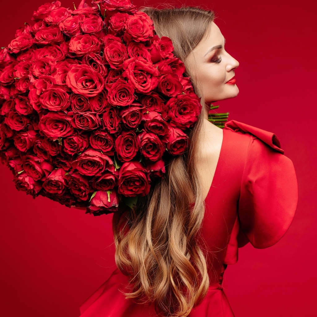 Девушка в красном платье с большим букетом роз