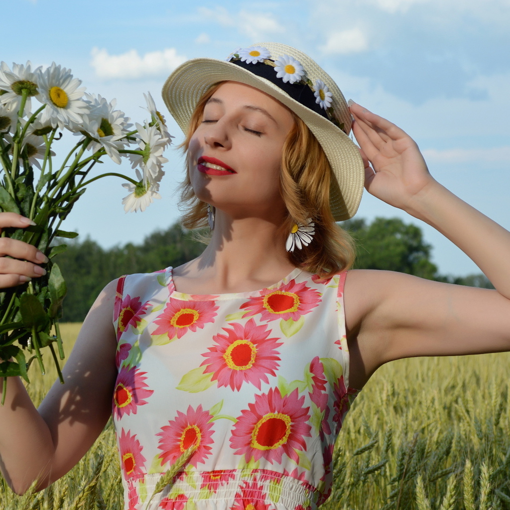 Девушка с букетом ромашек на поле