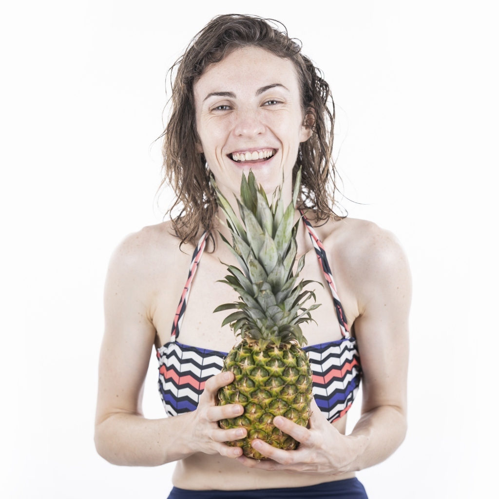 Улыбающаяся девушка с ананасом в руках