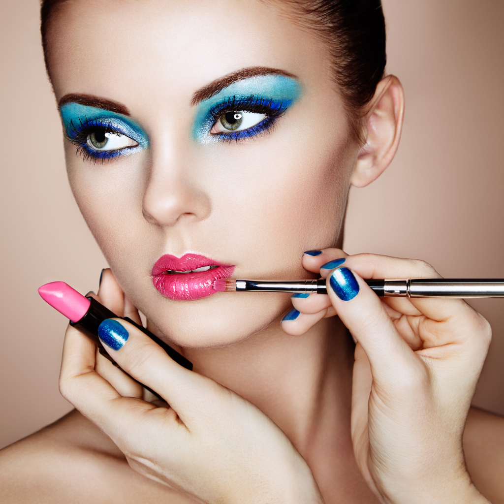 Девушке делают красивый яркий макияж