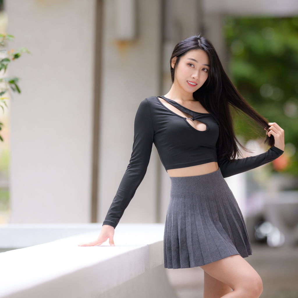 Молодая азиатка в короткой серой юбке