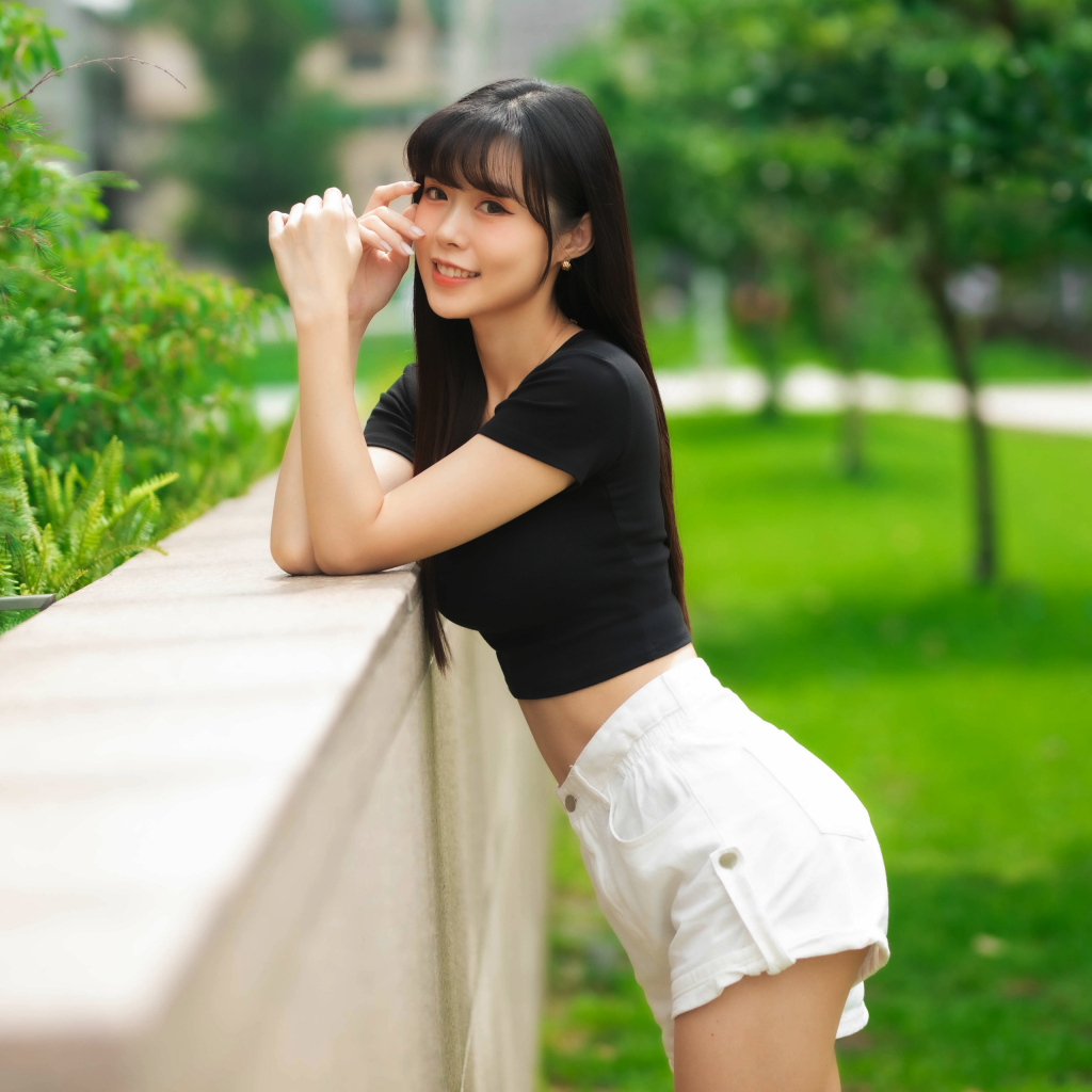 Молодая азиатка в белых шортах и футболке