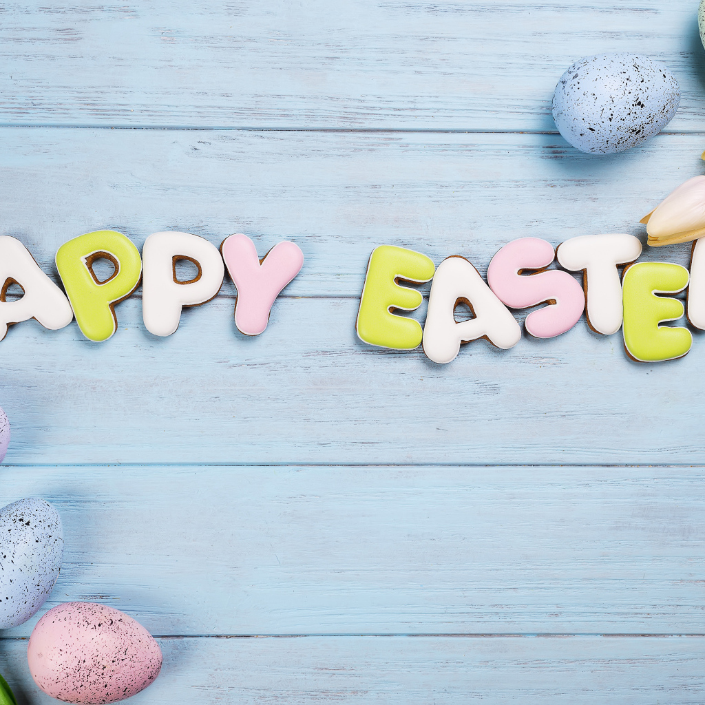 Печенье с надписью счастливой Пасхи с яйцами и цветами