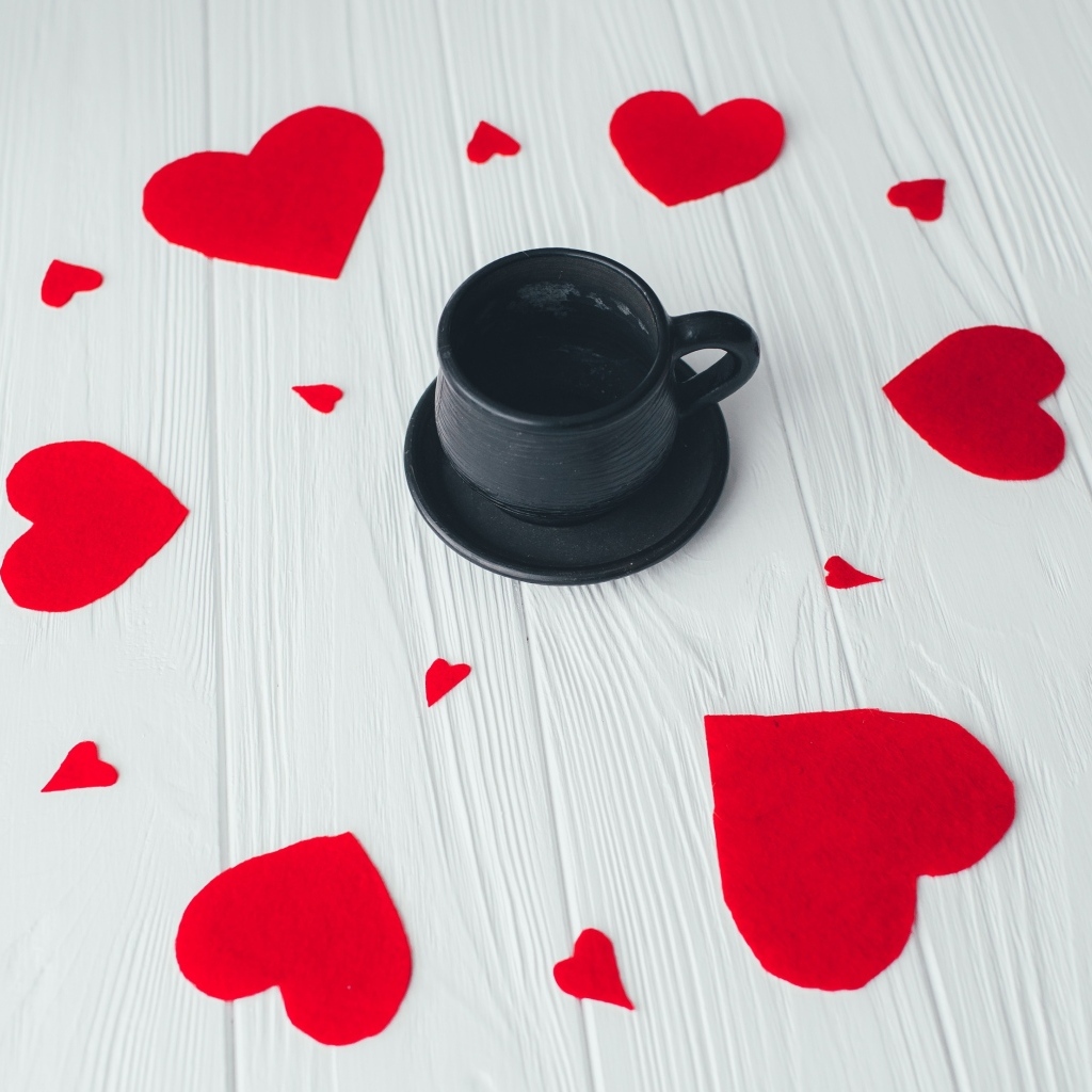 Чашка кофе с красными сердечками на столе
