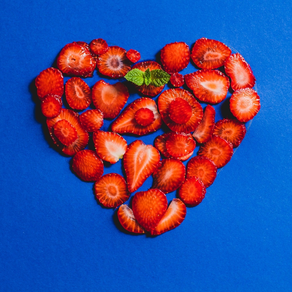 Сердце из сушеной клубники на синем фоне
