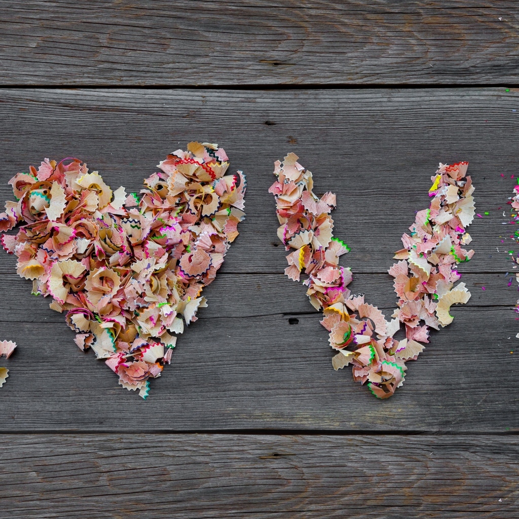 Надпись любовь из стружки карандашей на деревянном фоне