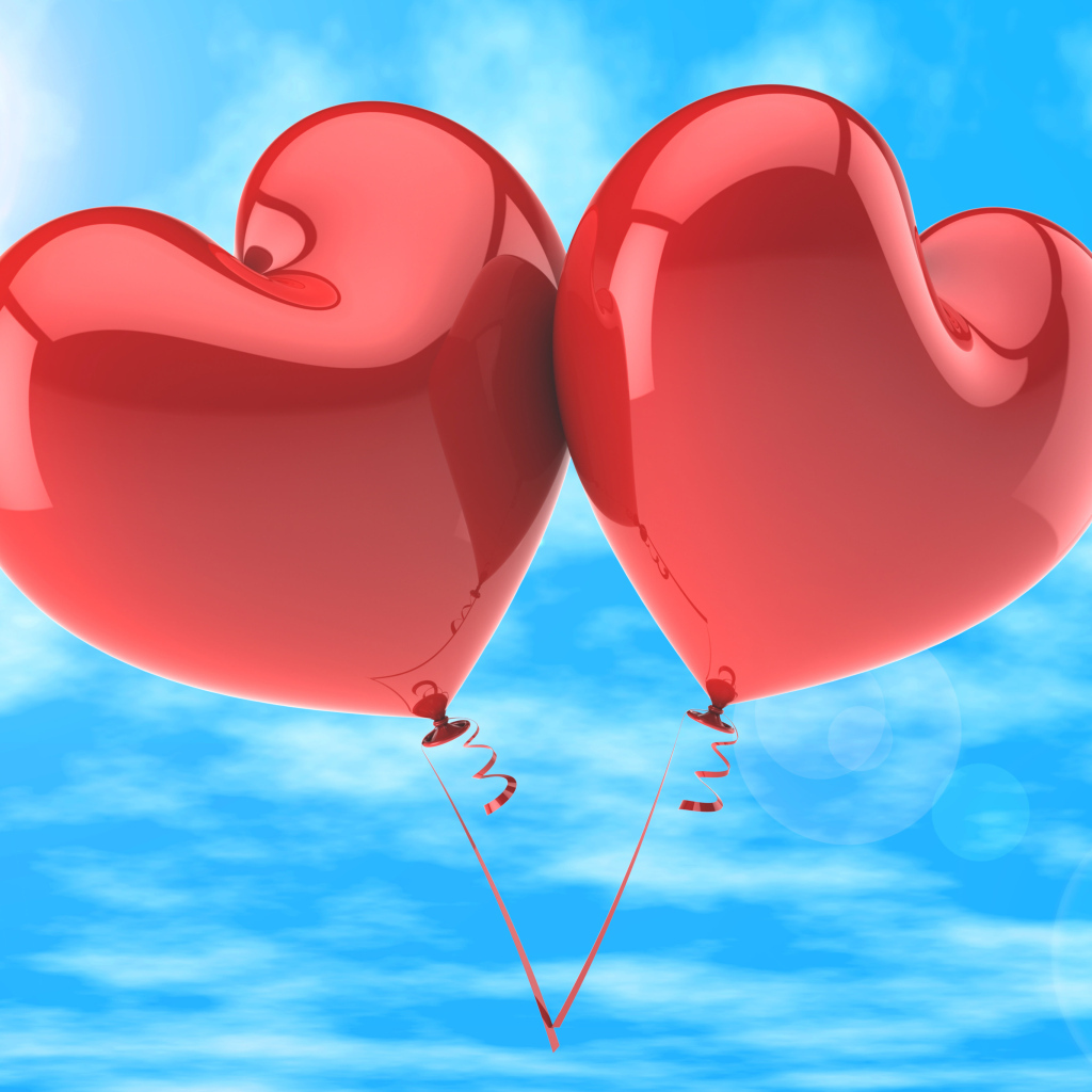 Два красных шарика в форме сердца в голубом небе