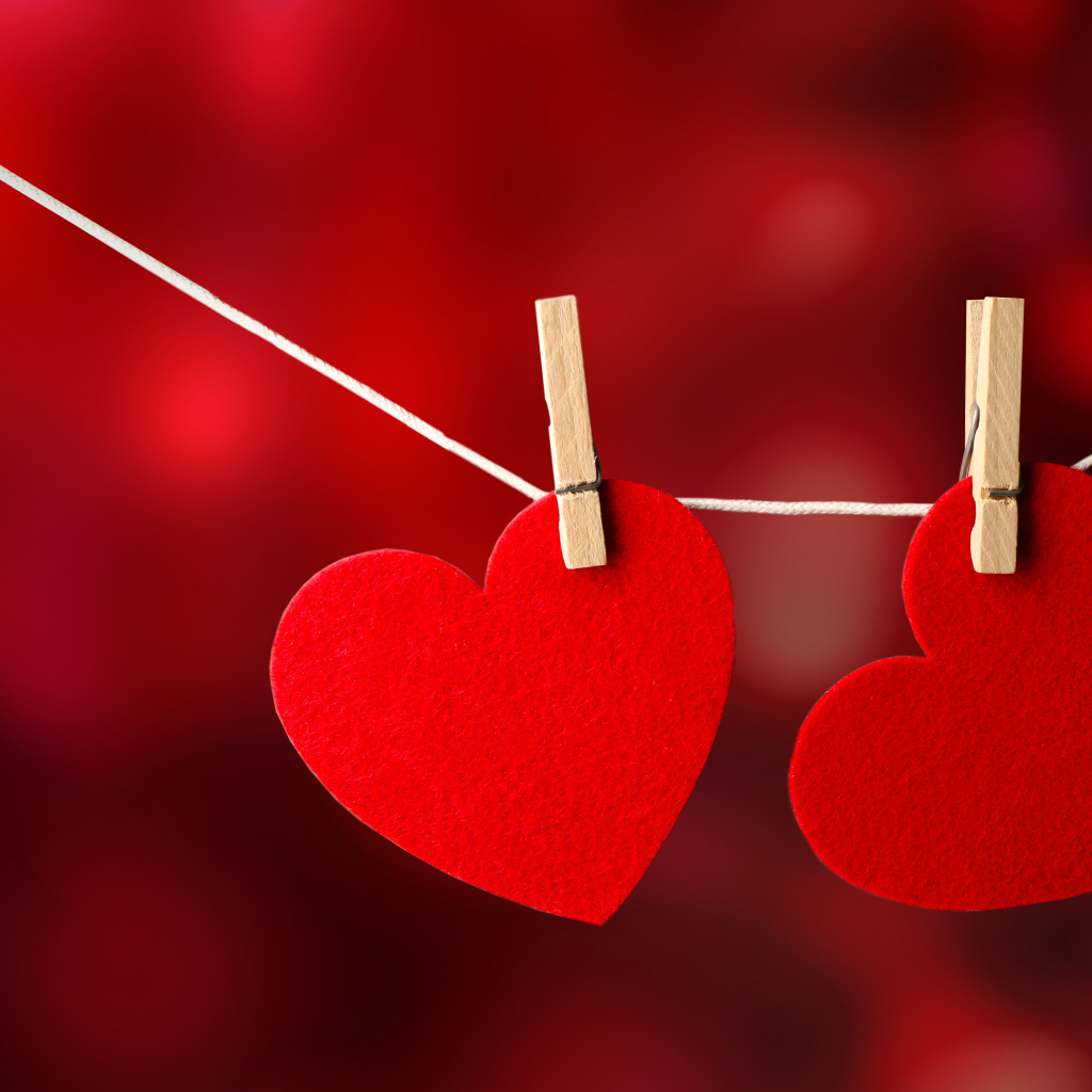 Два красных сердца висят на веревке
